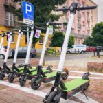 hulajnogi elektryczne, chodnik, samochody, budynek