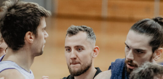 Zawodnicy stoją na parkiecie